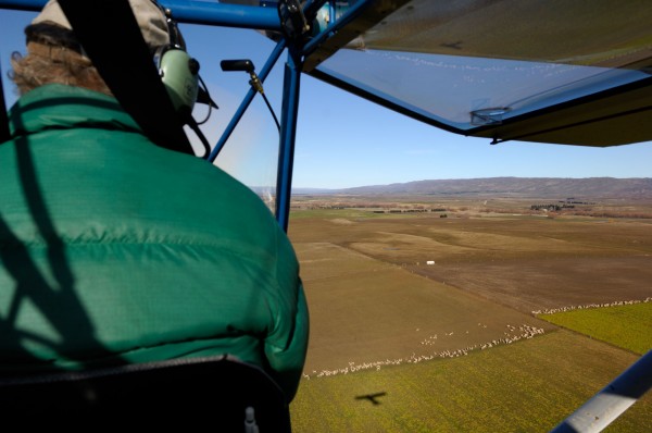 105_centralotago_bodyimage1 At the controls of his RANS S7 Courier, Dave Witherow contemplates the shadow of his microlight moving over the austere landforms of Central Otago near Ranfurly.