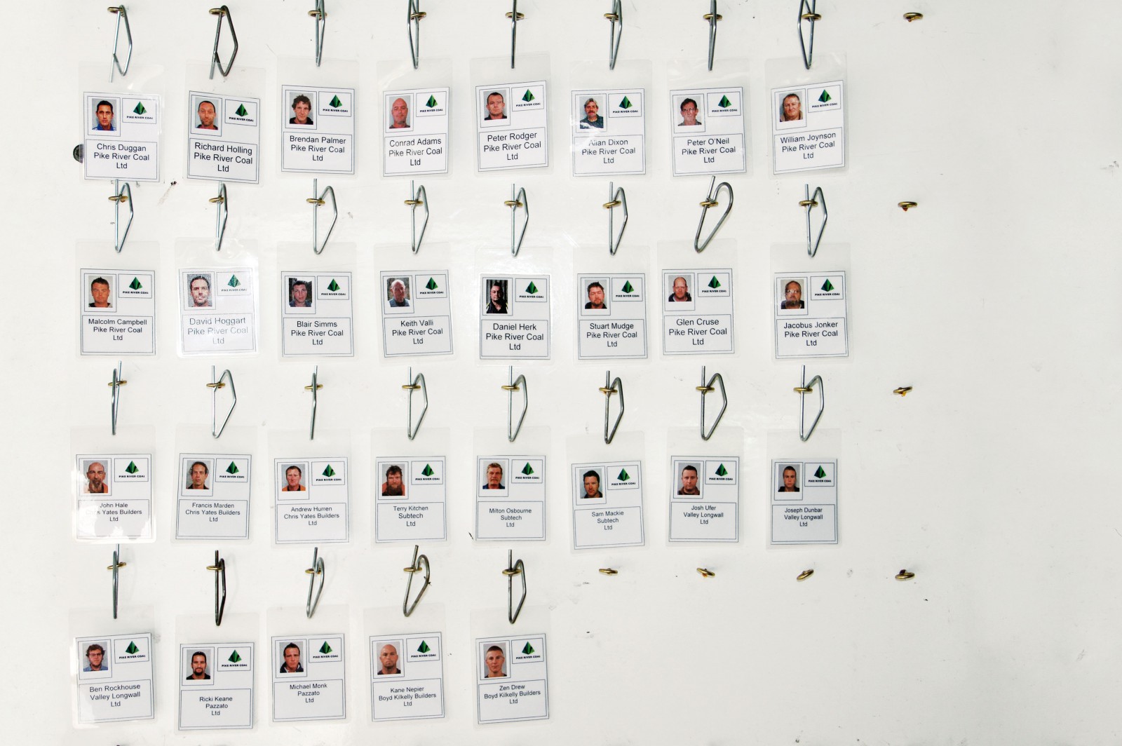 Faces of the 29 men trapped in the Pike River Coal Mine stare from a tag board—a system used to keep track of who is underground at any given time. 