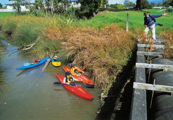 60_Opanuku_07 From atop a stormwater pipe, Ben Copedo, who guides historical walks in the Henderson area, describes local features to the paddlers. Yet another supermarket trolley has been sent to a watery grave here—sad testimony to the low regard many people have for the streams of suburbia.