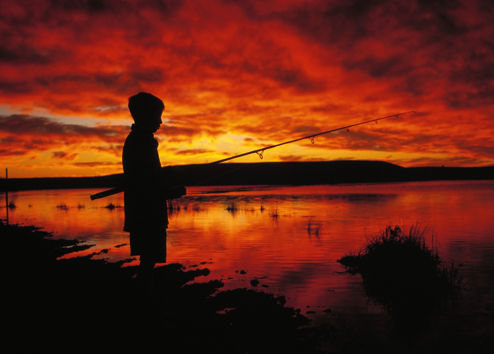 51_Waitaki_15 A young angler, out at dawn, tries his luck near the broad mouth of the Waitaki. Appreciated as snow by visitors to Mt Cook National Park, used to generate close to a third of our electricity, enjoyed by myriad boaties and anglers, employed to irrigate dozens of new dairy farms-are the waters of any other river of comparable value to the nation?